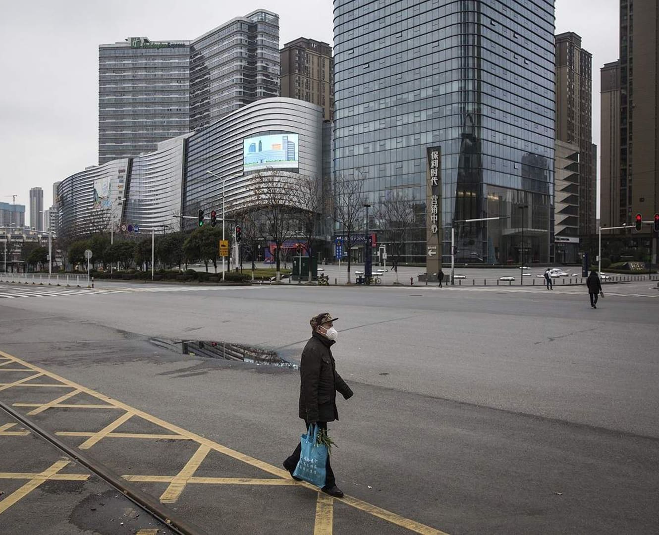 Woman walks through empty street in Shanghai China