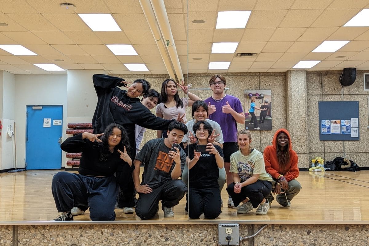 hip hop dance club nait students from NAIT's hip hop dance club take a mirror selfie. they are all grouped together and smiling.