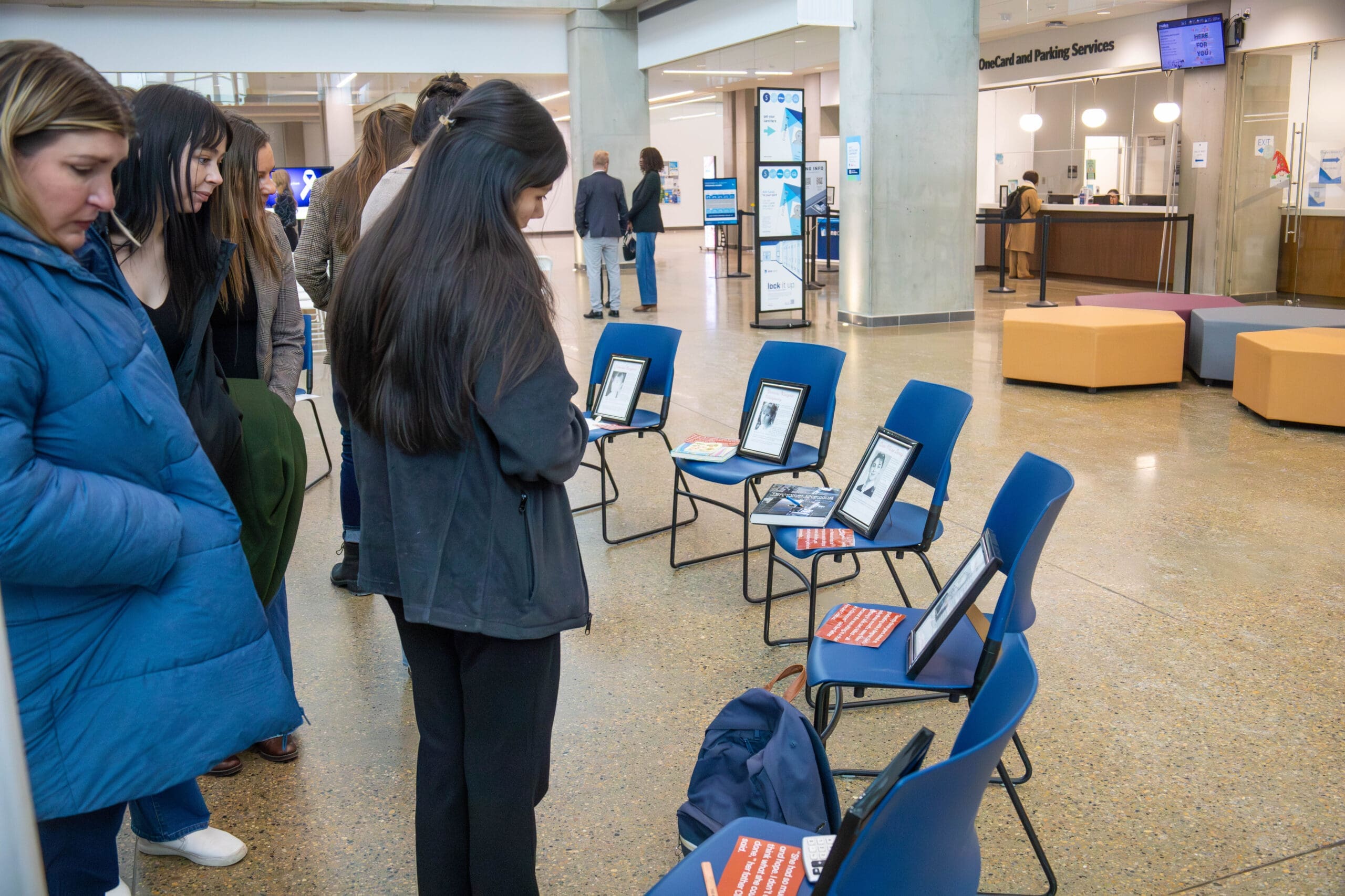 Attendees gather solemnly to read about each woman who died on Dec. 6, 1989. Photo by Mathieu Durnford