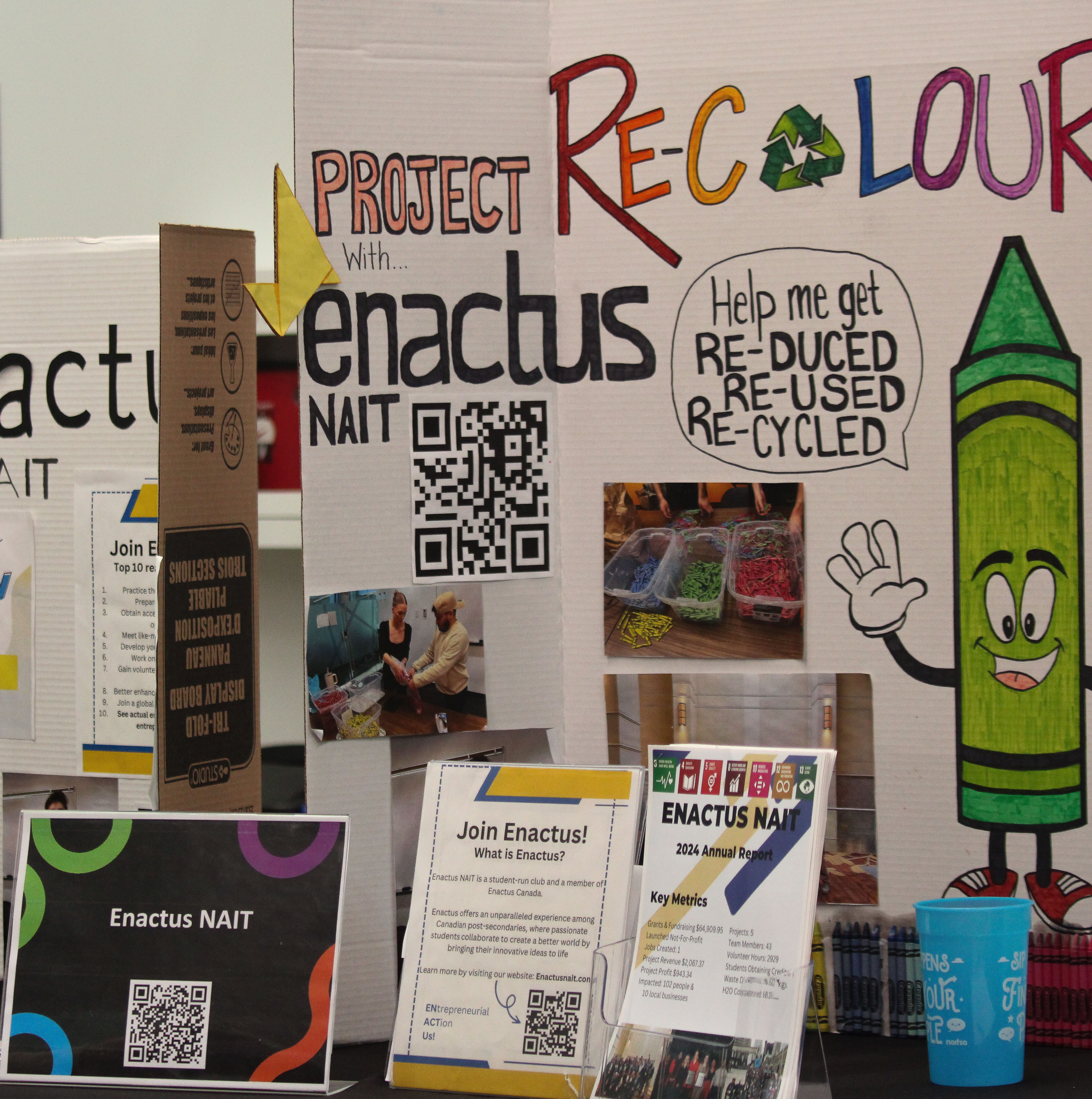 Photograph of the Enactus NAIT club table filled with full poster boards during Club showcase